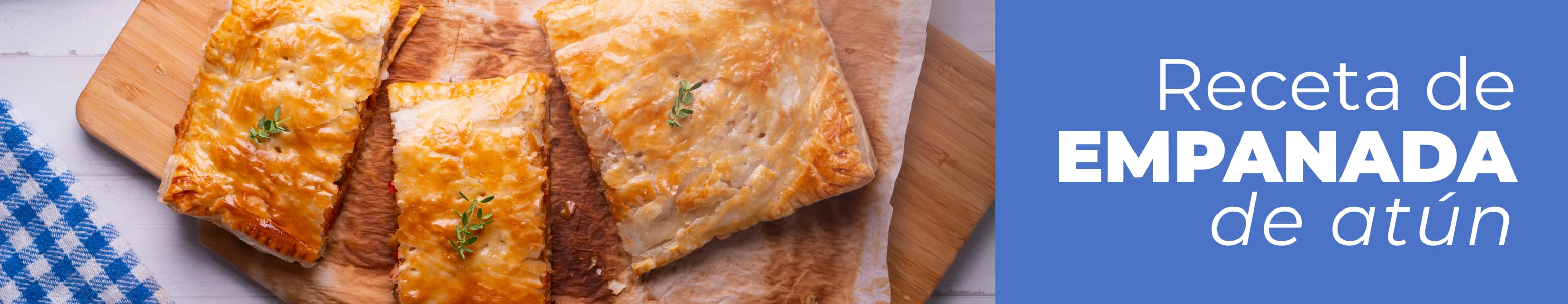 Table de madera con una empanada casera de atún con pisto ya terminada y muy dorada